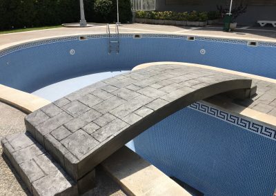 Pavimento impreso molde silleria color gris puente piscina comunitaria.
